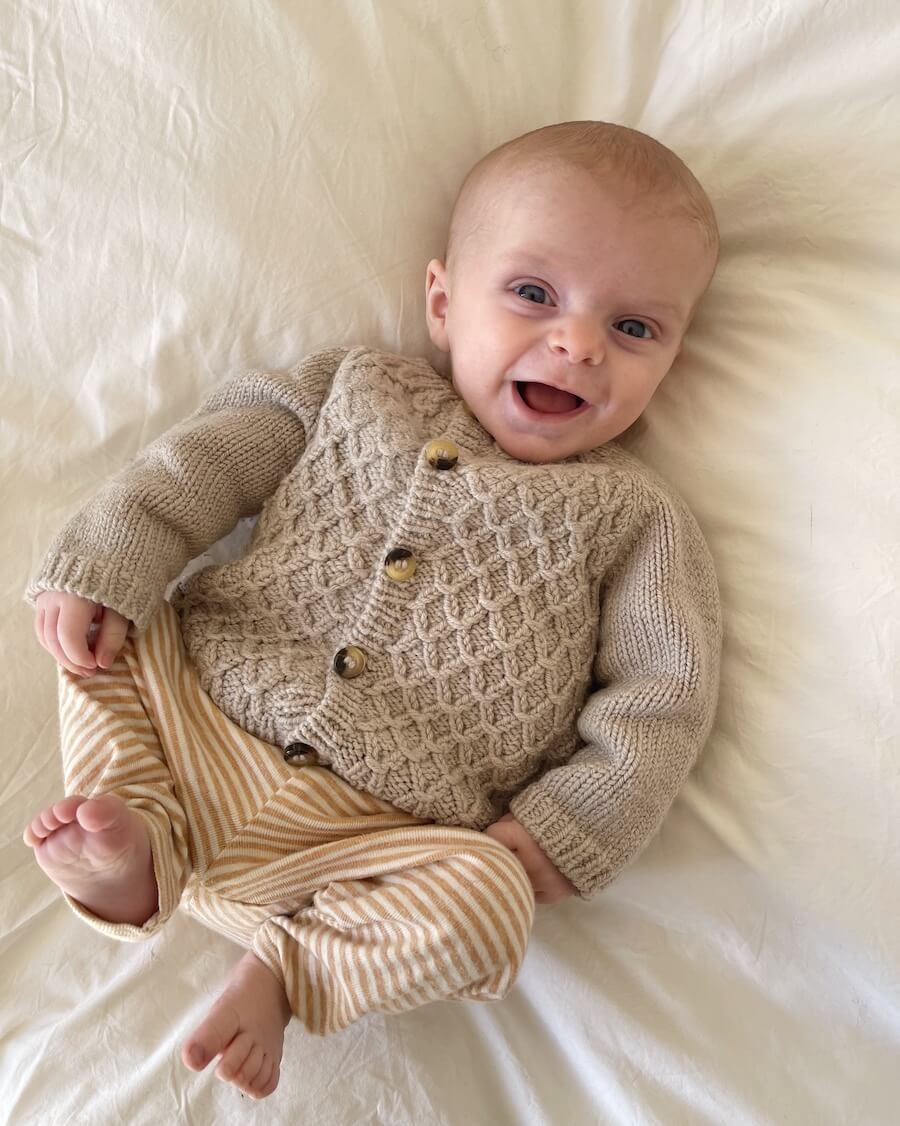 Baby draagt PetiteKnit Carl's Cardigan