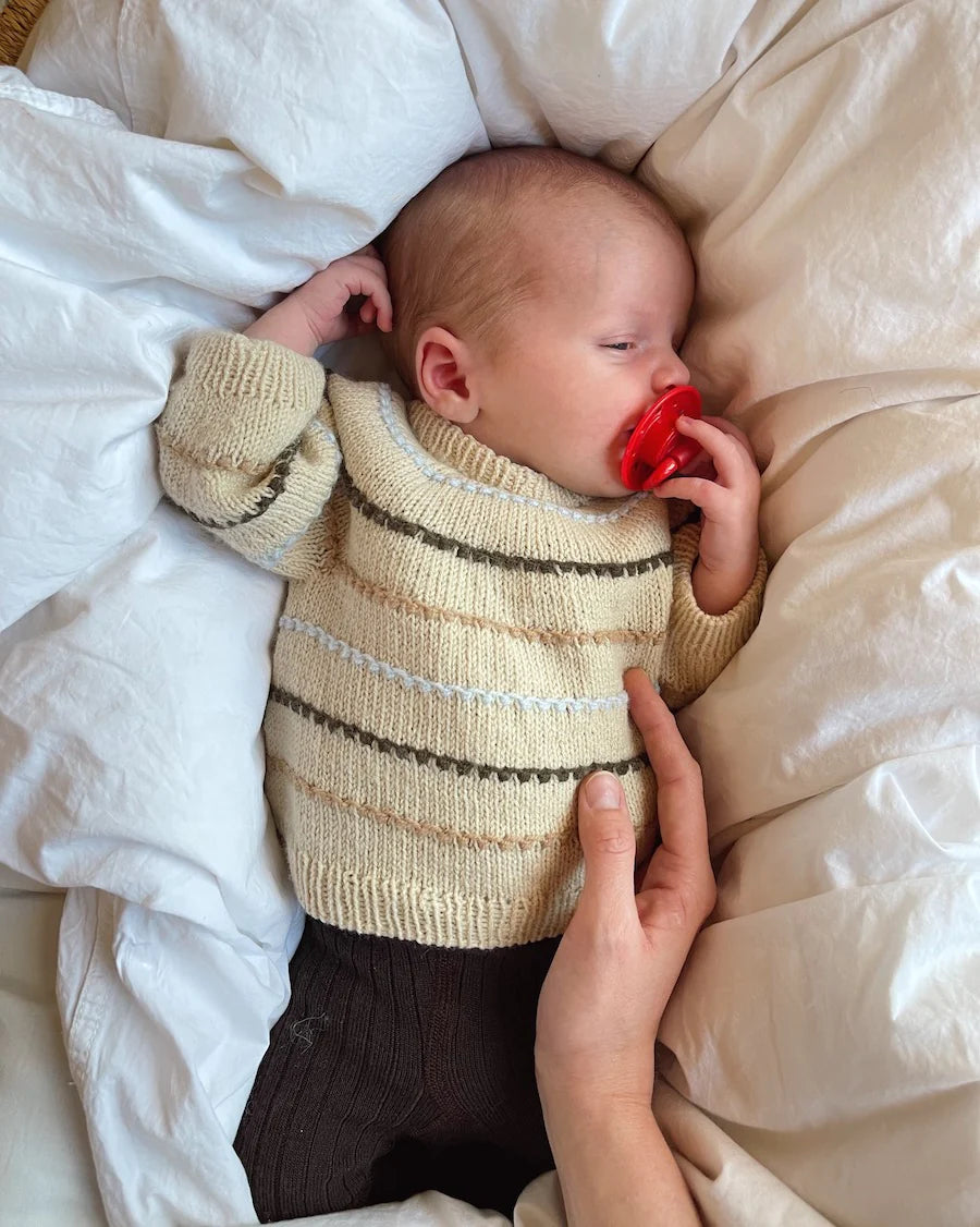 Baby draagt PetiteKnit Festival Sweater Baby